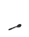 Black matte spoon by Alessi, lying angled on a white surface.
